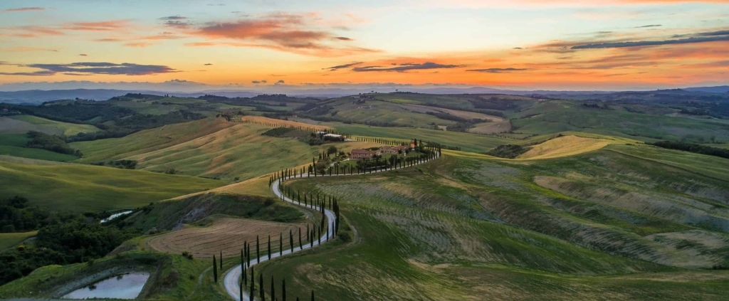 View on the Tuscan countryside at sunset. The hills are full of green cypresses, typical trees from Italy