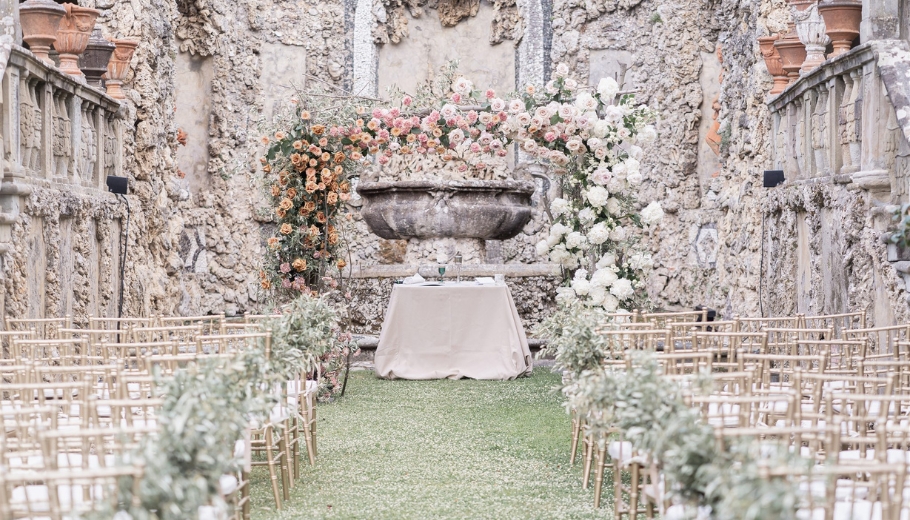 A scenic wedding ceremony in Italy, highlighting a lovely outdoor space decorated with flowers and a stunning arch for vows.