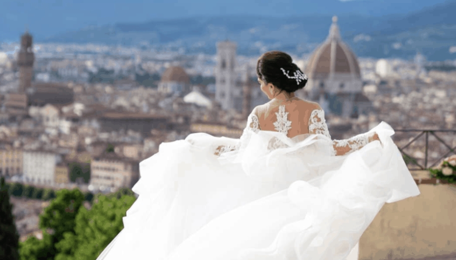 A bride in a wedding dress looks out at the city, representing the dream of an Italian wedding destination.