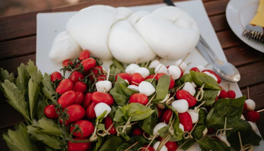 A beautifully arranged platter of fresh vegetables and cheese on a table, set for a luxury wedding in Italy.