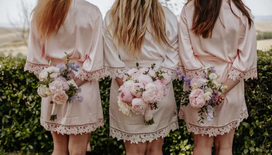 Bride and bridesmaids with bouquet of buttercups and flowers