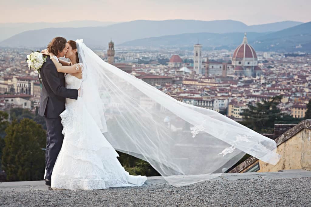 Bride and Groom kissing each other having Florence’s Dome as background