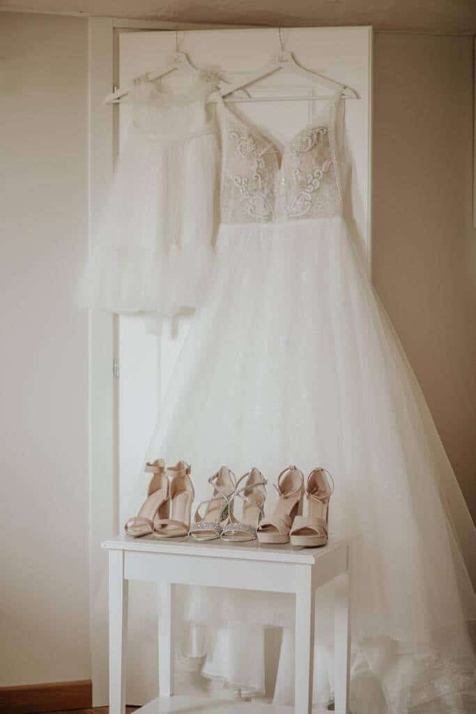 Picture of bride’s and her daughter dresses, below there are ivory wedding shoes