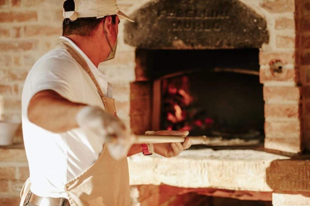 An expert italian pizzaiolo is making pizza for all of guests of Tuscan Villa Wedding 
