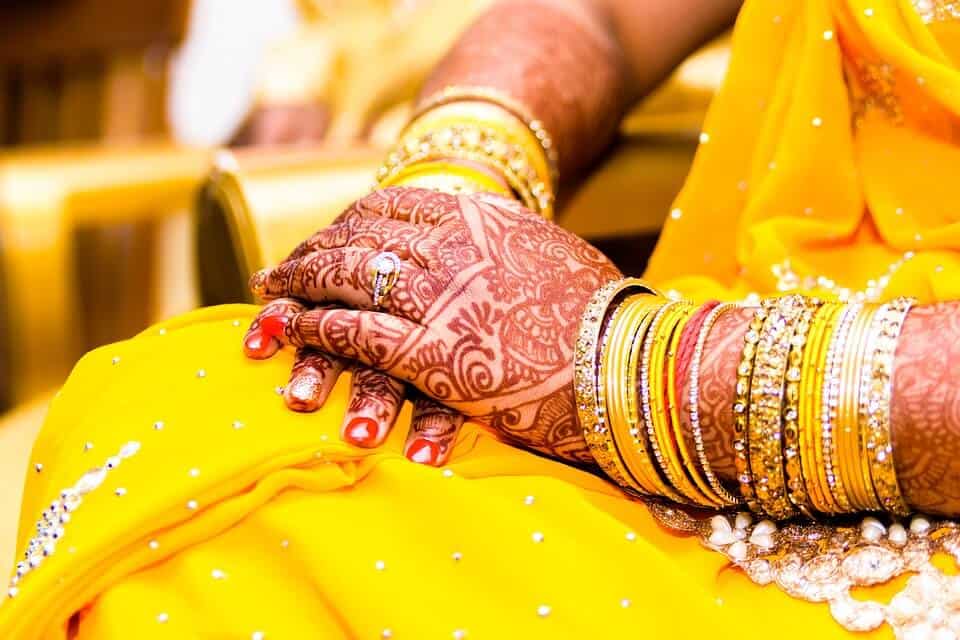 hindu bride in yellow traditional dress and tattoed hands