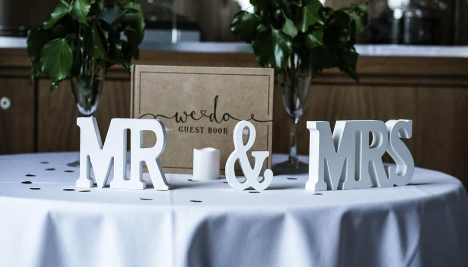 A table displaying two wooden letters, labeled as a wedding gift table, elegantly arranged for a special occasion.