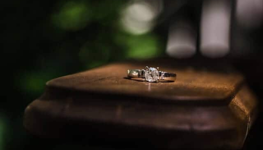 A diamond engagement ring placed on a wooden bench, symbolizing a perfect marriage proposal.