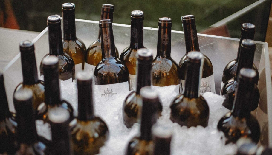A collection of wine bottles arranged in a metal tray, designated as the signature drink for a wedding event.