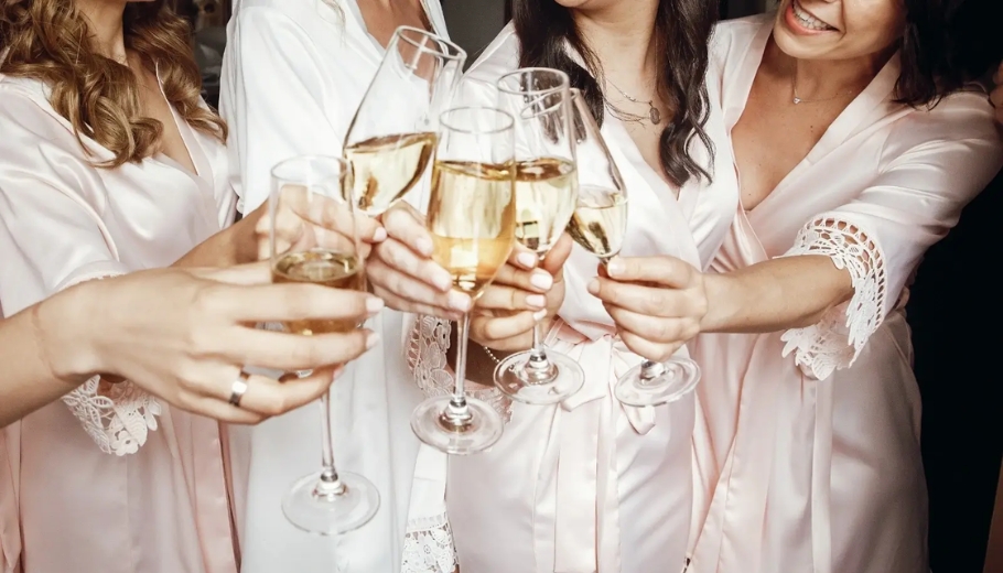 A group of bridesmaids joyfully toasting with champagne at a wedding bachelorette party.