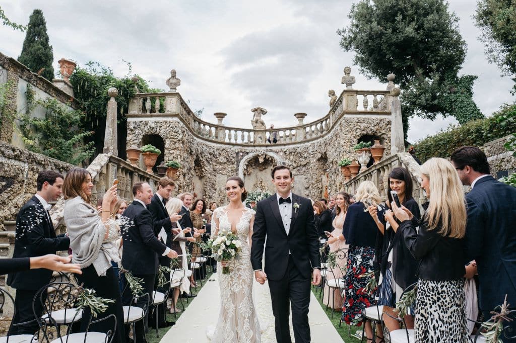 Beautiful Italian garden venue with a couple exchanging vows in front of guests.