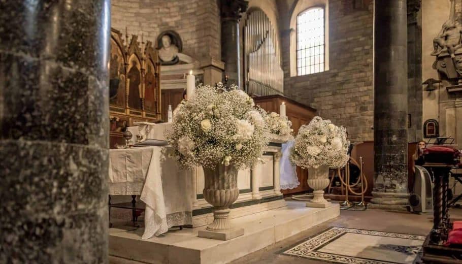 An elegant church ceremony rituals featuring white flowers and candles, reflecting the beauty of Italian wedding traditions.