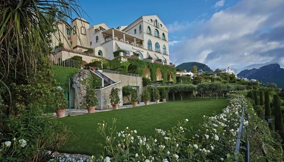 A charming villa set amidst lush greenery and blooming flowers, perfect for a dream wedding at Caruso, a Belmond Hotel.