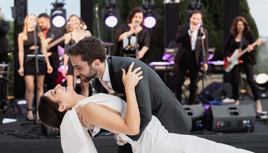 A joyful bride and groom kiss on the dance floor, capturing the essence of their perfect wedding celebration in Italy.